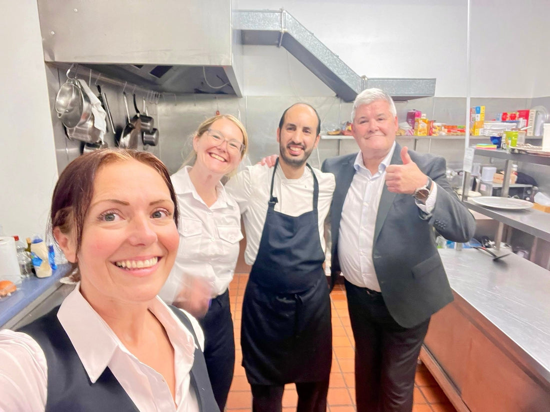 Chef Anas with the two front-of-house team members and a guest giving a thumbs up in the kitchen at Teaninich Castle near Alness, after a 50th-birthday banquet